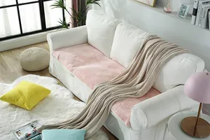 Detail of soft pink faux rabbit fur sofa cover on a white couch with home decor