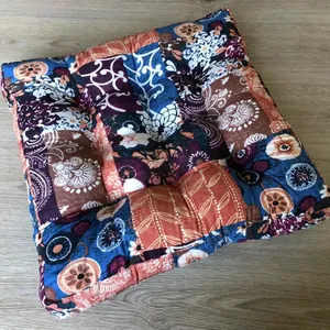 Close-up of bohemian patchwork floor cushion with mandala patterns on wooden floor