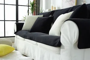 Detail of plush black faux rabbit fur sofa cover with matching pillows in a modern living room