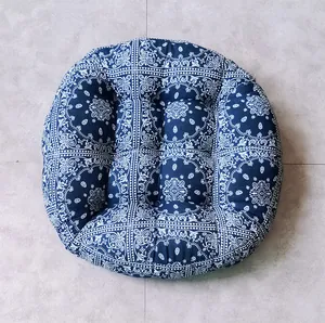 Macro view of blue paisley round cushion showing button tufting and thick cotton texture