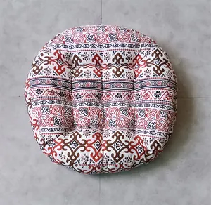 Macro view of a bohemian round floor cushion featuring intricate patterns and tufted stitching