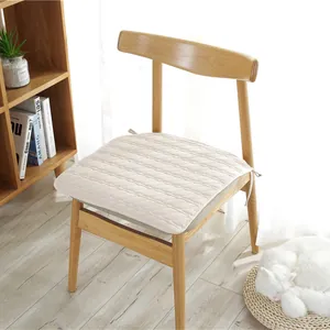 Cojín acolchado de algodón crema para silla con lazos antideslizantes en un ambiente hogareño