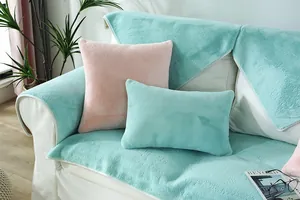 Detail of plush faux rabbit fur sofa cover and matching pillows in mint green and pink