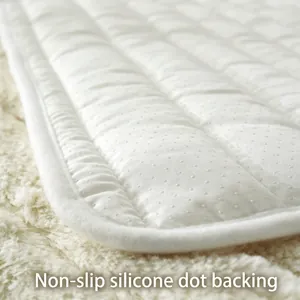 Dettaglio del retro antiscivolo in silicone e del bordo trapuntato sul copridivano