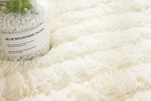 Dettaglio del tappetino per davanzale in peluche bianco crema con morbida pelliccia