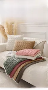 Detail of plush velvet sofa cushion with leaf vein quilting and soft white faux fur trim