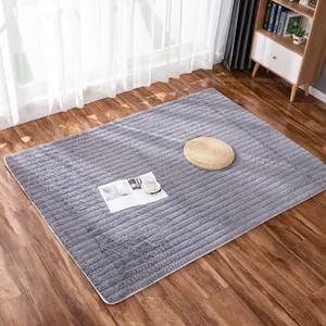 Dettaglio del tappeto grigio peluche con trama a strisce e bordo bianco cucito