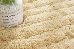 Dettaglio del tappeto in peluche beige per davanzale con trama a onde in finta pelliccia