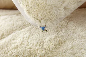 Close-up of thick cream plush sofa cushion with dense faux fur texture and soft pile