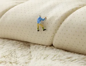 Close-up of non-slip silicone backing on plush sofa cushion with miniature hiker