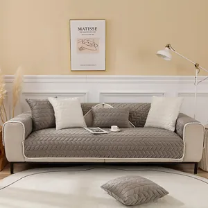 Close-up of gray quilted sofa cover with leaf patterns and elegant wavy lace trim