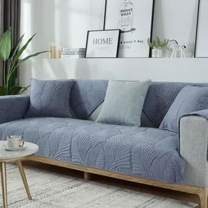 Détail de la housse de canapé bleue en chenille avec motif feuilles et texture antidérapante
