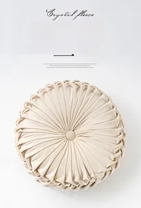 Close-up of the pleated pumpkin-shaped velvet cushion with center button detail