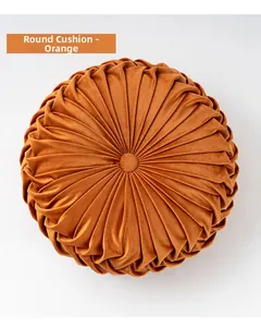 Detailed close-up of orange pumpkin wheel cushion with radial pleated velvet texture