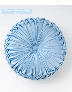 Detail of light blue velvet round pumpkin cushion with radial pleats and button