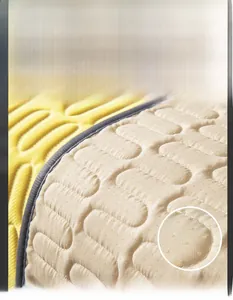 Detail of non-slip particles on the back of a beige latex cooling sofa mat