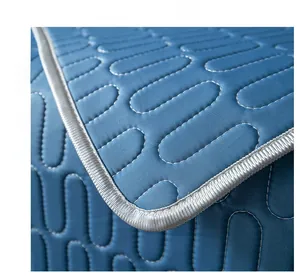 Macro detail of blue latex ice silk sofa mat showing quilted texture and silver piping