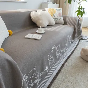 Detail of dark gray cotton linen sofa cover with white bear pattern and fringed edges