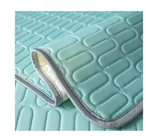 Detail of mint green ice silk cooling sofa mat with capsule quilted pattern and gray piping