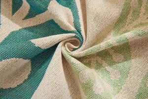 Close-up of woven cotton sofa cover featuring blue tropical leaf jacquard texture