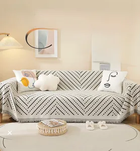 Detailed view of chenille sofa cover with geometric stripes and decorative tassels