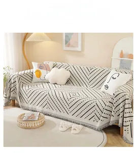 Detail of black and white geometric sofa cover with fringe edges and woven texture