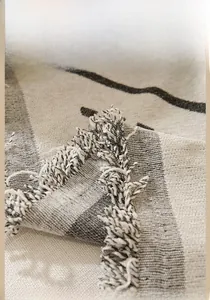 Close-up of geometric woven sofa cover fabric with stylish tassel fringe details
