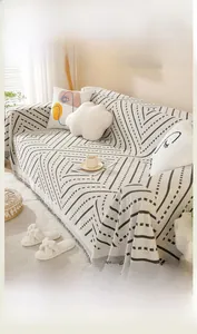 Detail of soft cotton sofa cover with black and white geometric patterns and tassel edges