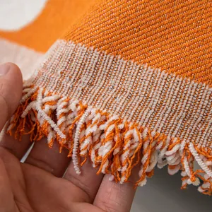 Orange and beige striped anti-scratch sofa cover with decorative fringed tassels