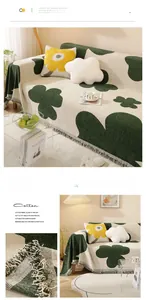 Detailed close-up of dark green floral pattern and fringe on cotton sofa cover blanket