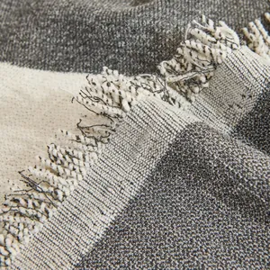 Close-up of chenille sofa cover showing striped texture and soft tassel fringe details