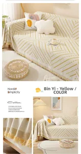 Close-up of beige geometric woven cotton sofa cover featuring detailed tassel edge decor
