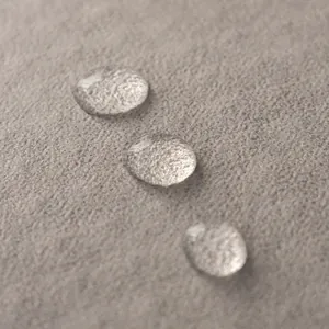Housse de canapé imperméable en tissu taupe avec gouttes d'eau sur la surface