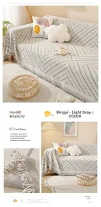 Close-up of light gray cotton sofa cover with Nordic geometric pattern and tassels