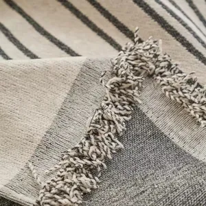 Modern chenille sofa cover with neutral striped pattern and decorative tassel edges