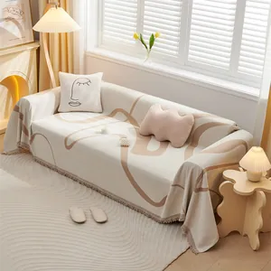 Detail of cream chenille sofa cover with brown abstract lines and delicate fringe edges