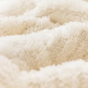 Copridivano in pile bianco morbido con trama antiscivolo e stile invernale moderno