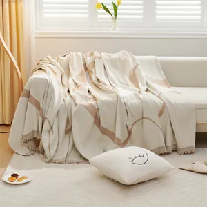Nordic chenille sofa throw cover with brown abstract lines and fringe tassels in natural light