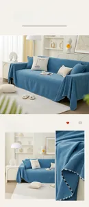 Close-up of blue chenille sofa cover featuring rice grain texture and white ball fringe