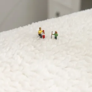 Tapis moderne en laine d'agneau avec figurines miniatures créant un paysage enneigé