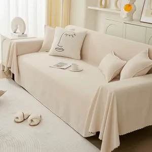 Detail of beige textured sofa cover with minimalist line art face embroidery pillow