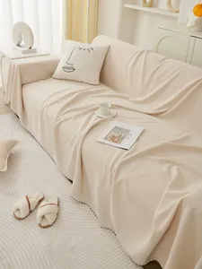 Detail of cream striped sofa cover featuring decorative black polka dot stitching edges
