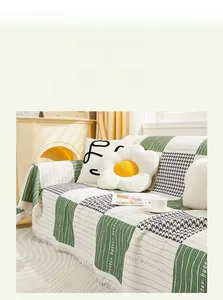 Detail of green and beige checkered cotton sofa cover with tassels and eco-friendly dyeing