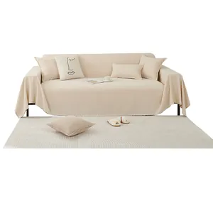 Minimalist cream sofa cover set with matching pillows and textured rug on white background