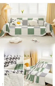 Detail of green checkerboard sofa cover with jacquard texture and white tassel fringe
