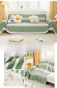 Close-up of green vertical stripes and grey polka dot sofa cover with white tassels