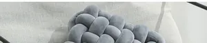 Gros plan détaillé du coussin nœud en velours gris montrant la texture tressée