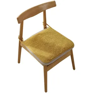 Ginger yellow plush lamb wool chair cushion with ties on a light wood chair