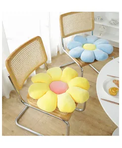 Detail of plush flower cushions in yellow and blue corduroy on a rattan chair