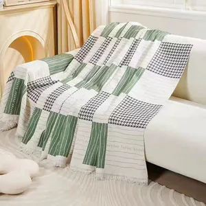 Green and cream patchwork sofa cover blanket with houndstooth pattern and fringe trim